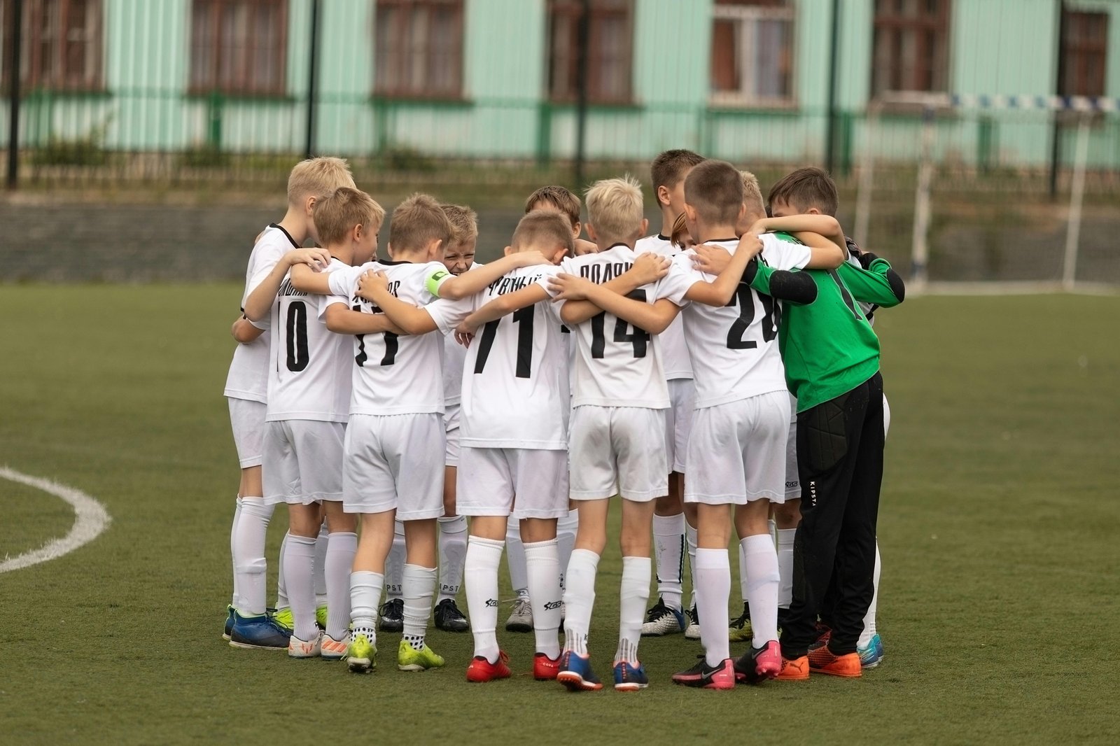 Youth soccer team in a huddle on the field